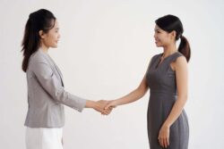 Two Japanese business women greeting each other