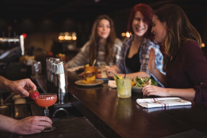 Women at a bar talking using Dutch words