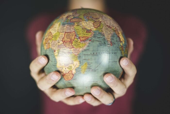 Shot of a person holding a globe with two hands to show the importance of Chinese and Japanese