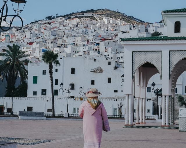 Tourist in Morocco looking towards the white hillside buildings and Moroccan architecture of Tétouan.