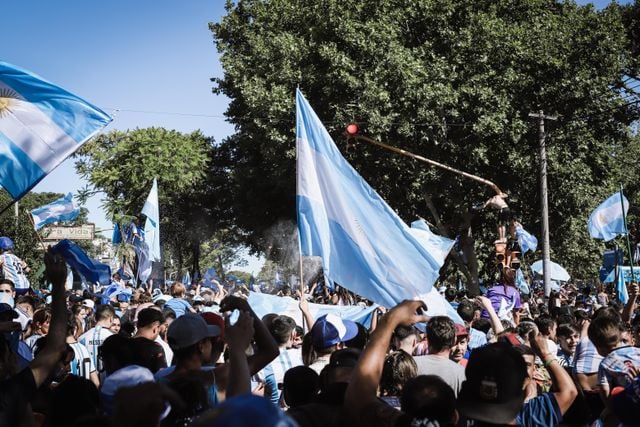 Crowd waving Argentine flags, representing the everyday use of vos in Argentine Spanish.