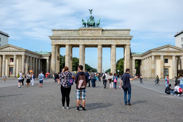 Tourists near the Brandenburg Gate using common German direction phrases.
