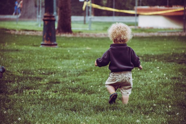 Child running through a park, illustrating how Portuguese diminutives can express small size, affection, and familiarity.