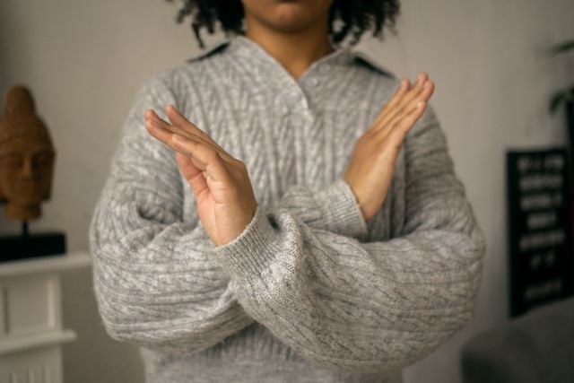 Person crossing their arms to signal “no,” illustrating how Turkish verbs are made negative.